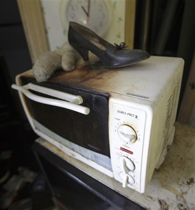 A women's shoe rests on a microwave in the home of Anthony Sowell Monday, June 27, 2011. Jurors preparing to hear opening statements Monday visited the property.  Sowell is charged with killing 11 women and hiding their remains in and around his property. (AP Photo/Marvin Fong, Pool)